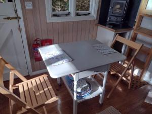 a table and chairs in a room with a stove at Cabin in the Woods in Ardingly +7 photos
