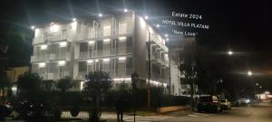 un edificio con un lampione di fronte ad esso di notte di Hotel Villa Platani a Riccione