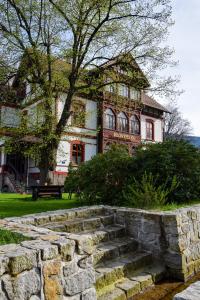 une maison avec un escalier en pierre en face d'un bâtiment dans l'établissement Willa Słoneczko, à Szklarska Poręba