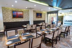 Un comedor con mesas y sillas de madera. en PARK SIGNATURE HOTELS - Royal Benza, en Vijayawāda