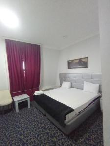 sypialnia z łóżkiem i fioletową zasłoną w obiekcie Karizma hotel w mieście Baku