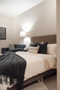 1 dormitorio con 1 cama grande con almohadas blancas y negras en Minilove Homestay, en Tainan