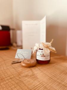 a jar of honey sitting on a wooden table with a cookie at Agriturismo Il Cucchiaio di Legno in Orta San Giulio