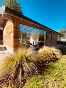 a small house with large windows and grass at Agriturismo Il Cucchiaio di Legno in Orta San Giulio