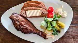 einen Teller mit Fleisch, Brot und Gemüse in der Unterkunft Pension & Biergarten Spreewaldhof Leipe in Leipe