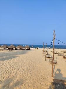 uma praia com algumas cadeiras e guarda-sóis e o oceano em View Nhat Le Beach Hotel em Dong Hoi