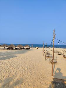 a beach with some chairs and umbrellas and the ocean at View Nhat Le Beach Hotel in Dong Hoi