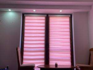 a table in front of a window with pink lights at Exclusive apartments Visoko 2022 in Visoko