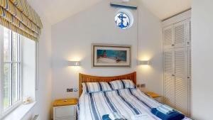 a bedroom with a bed with a clock on the wall at Salty Dog at The Bay Filey, sleeps 4, 2 dogs welcome for free too in Filey +20 photos