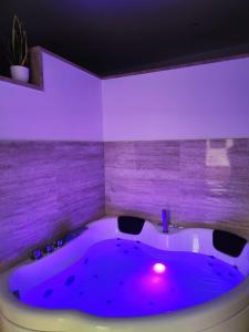 een paarse kamer met een bad met paars licht bij B&B Terrazza In Centro in Castellammare di Stabia