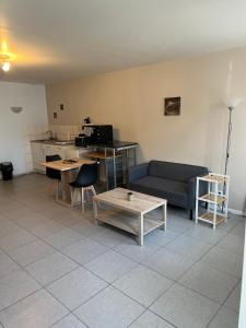 a living room with a couch and a table at Cosy Studio in La Celle-sur-Loire