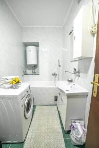 a white bathroom with a washing machine and a sink at Apartman GIF in Trebinje