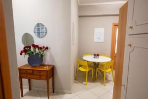 una piccola sala da pranzo con tavolo e sedie gialle di Renza House Chiaia a Napoli