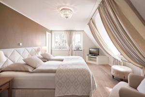 a bedroom with a large white bed and a window at Senhoog in Nieblum