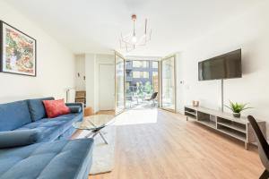 a living room with a blue couch and a tv at Massy Serenity - 64m2, Terrace, Balcony, Parking in Massy