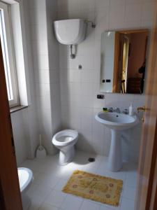 Baño blanco con aseo y lavamanos en Casa Bianca, en Sant'Egidio del Monte Albino
