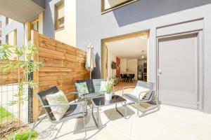 a patio with chairs and a table and a fence at Massy Serenity - 64m2, Terrace, Balcony, Parking in Massy