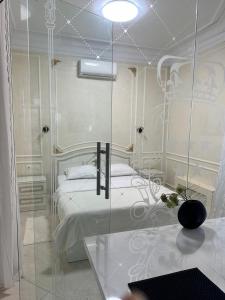 Апартаменты Аркадия في أوديسا: غرفة نوم بيضاء بسرير وجدار زجاجي