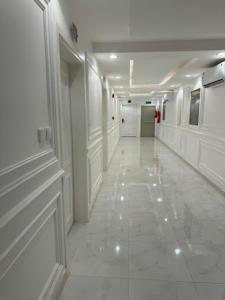 a hallway with white walls and a white tile floor at شقق درة العريش لشقق المخدومة in Jazan