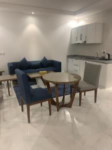 a living room with a table and chairs and a kitchen at شقق درة العريش لشقق المخدومة in Jazan