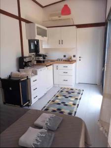 una cocina con armarios blancos y una mesa en una habitación en Athena Tiny House en Bodrum