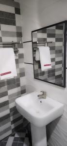 ラゴスにあるTripletee luxury hotelのバスルーム(白い洗面台、鏡付)