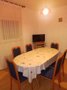 a dining room with a table and chairs and a television at Apartmani Ivan in Gornji Karin