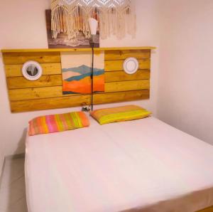 1 dormitorio con cama blanca y cabecero de madera en Platasun Terrace - with a breathtaking view, en Platamona