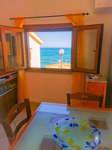 comedor con mesa de cristal y vistas al océano en Platasun Terrace - with a breathtaking view, en Platamona