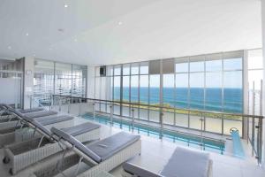 a swimming pool with a view of the ocean at Luxury at Fynbos 5 in Mossel Bay