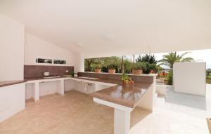 een keuken met witte werkbladen en een witte koelkast bij Country House con Piscina e Jacuzzi Villa delle Sterlizie in Partinico
