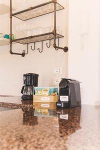 Country House con Piscina e Jacuzzi Villa delle Sterlizie في بارتينيكو: سطح كونتر مع محمصة وآلة صنع القهوة
