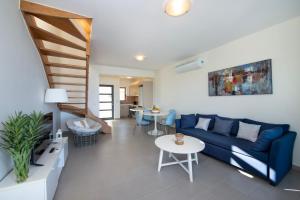 a living room with a blue couch and a table at Ashlin seaside Luxury Apartment in Chania Town