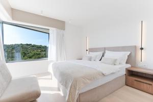 a white bedroom with a large window and a bed at Villa Isola in Murter +231 photos