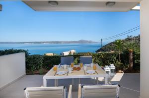 a white table and chairs with a view of the ocean at Ashlin seaside Luxury Apartment in Chania Town