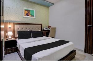 a bedroom with a large bed and a desk at Hotel New Blue Sapphire Residency in Mumbai