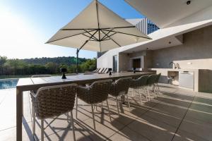 an outdoor bar with chairs and an umbrella on a patio at Villa Isola in Murter