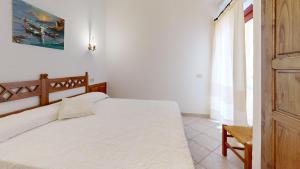 a bedroom with a large white bed and a window at Villetta Ginepri in Cannigione