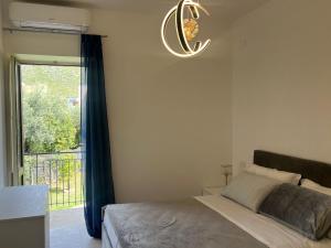 スペルロンガにあるSperlonga Apartmentのベッドルーム1室(ベッド1台、窓、シャンデリア付)