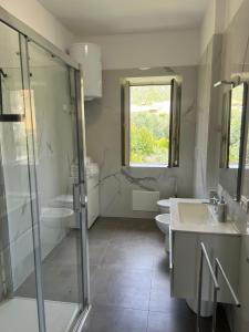 a bathroom with two sinks and a glass shower at Sperlonga Apartment in Sperlonga