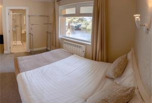 a bedroom with a large white bed with a window at Killarney View House B&B in Killarney