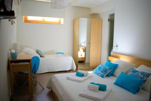 1 dormitorio con 2 camas, escritorio y espejo en Lo Scalo 2.0, en Marina di Ragusa