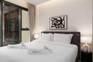 two beds in a hotel room with white sheets at Luxury Redefined in AHAD Residence by Suiteable in Dubai