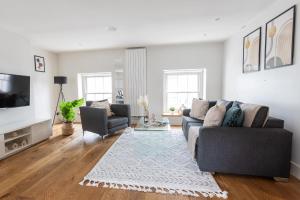 a living room with a couch and a tv at 2BR in Prime Soho & Fitzrovia - CityApartmentStay in London