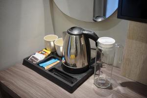 a tea kettle and cups on a tray on a table at Key Inn Hotel Bogor in Kamparganya