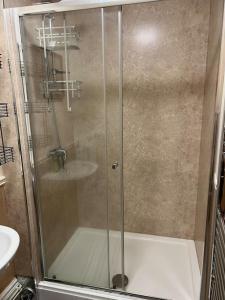 una doccia con porta in vetro in bagno di Spacious one bedroom flat w/ parking a Walsall