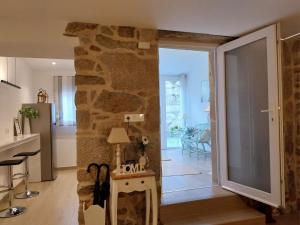 uma cozinha e sala de estar com uma parede de pedra em O berce casa rural camino Padrón Santiago em Padrón
