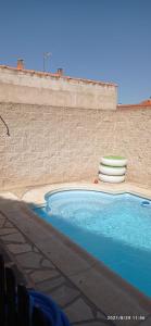 uma piscina ao lado de uma parede de tijolos em La Madriguera de Toledo em Bargas