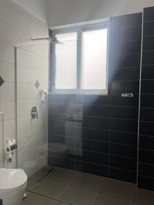 y baño con aseo y ducha acristalada. en Saranda Hotel, en Sarandë