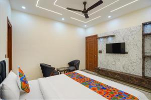 een slaapkamer met een bed en een flatscreen-tv bij The Grand Mansion Hotel in Greater Noida